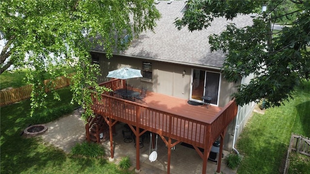 rear view of house featuring a shingled roof and a wooden deck