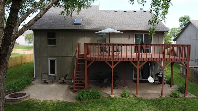 rear view of property with roof with shingles, a wooden deck, stairs, and a patio area