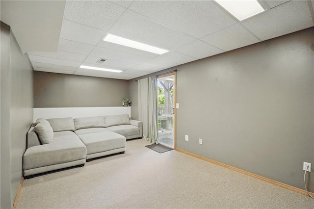 living room with a paneled ceiling, carpet flooring, and baseboards
