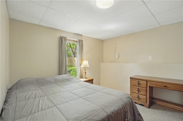 bedroom with a drop ceiling and carpet