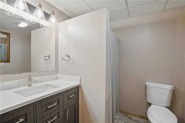 bathroom featuring toilet, vanity, a shower with curtain, and a paneled ceiling