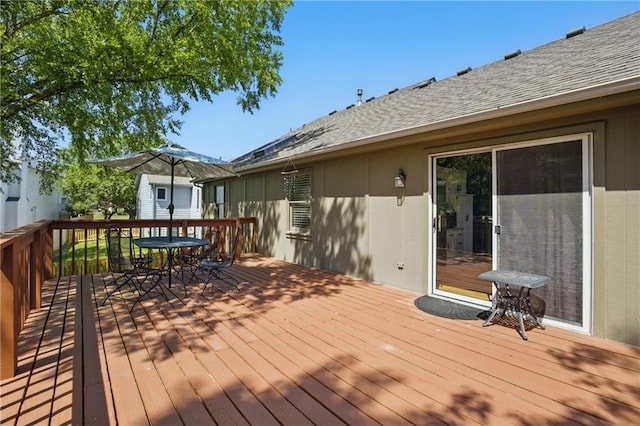 deck with outdoor dining space and an outbuilding