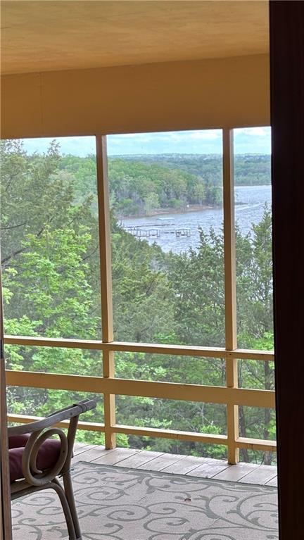 sunroom / solarium featuring a water view