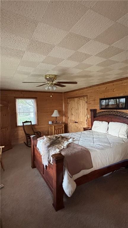 bedroom featuring wooden walls and carpet floors