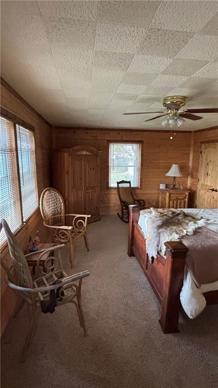 carpeted bedroom featuring wood walls
