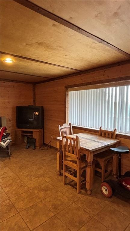 dining room featuring wood walls and light tile patterned floors