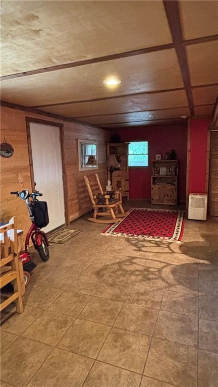basement featuring wood walls, light tile patterned flooring, and recessed lighting