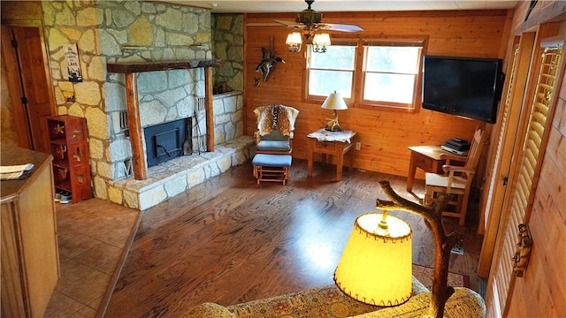 25996 Arrowhead Rd, Hermitage, MO 65668 - living area with ceiling fan, a fireplace, wood finished floors, and wood walls