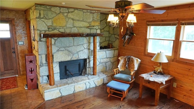 25996 Arrowhead Rd, Hermitage, MO 65668 - living area featuring a ceiling fan, a stone fireplace, and wooden walls