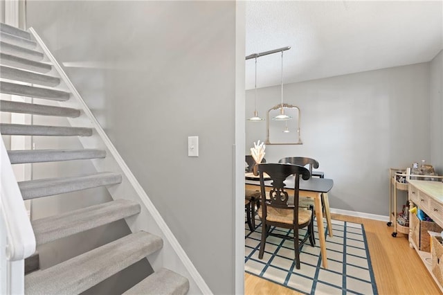 stairway with wood finished floors and baseboards