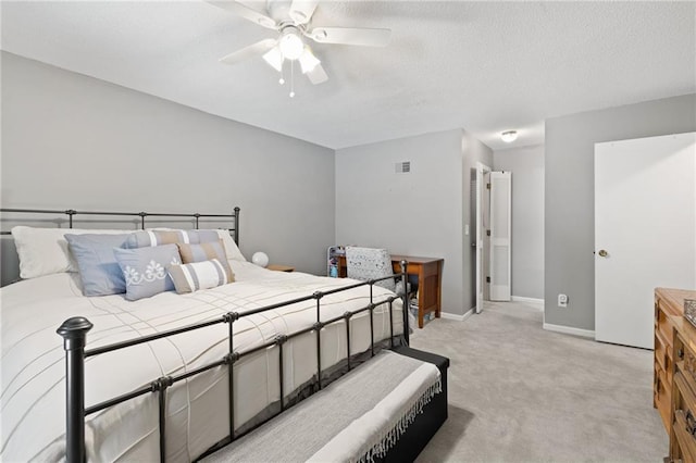 bedroom featuring light carpet, baseboards, ceiling fan, and a textured ceiling