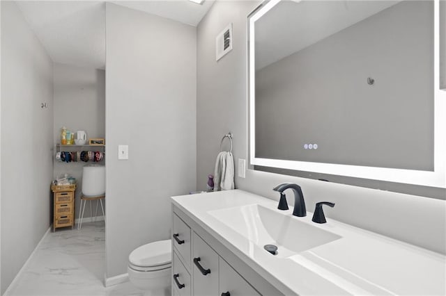 half bath featuring marble look tiles, toilet, vanity, and baseboards