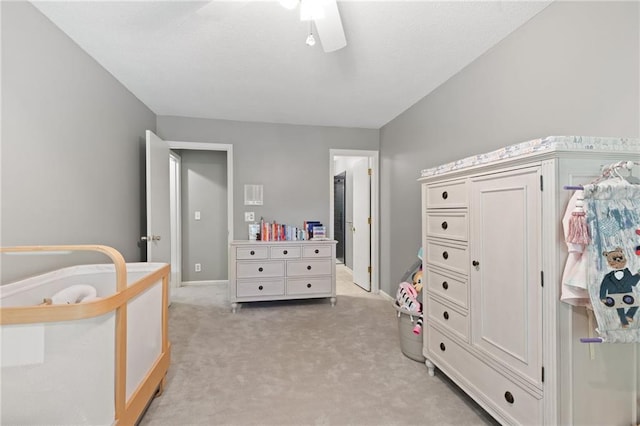 bedroom featuring light carpet, baseboards, and a ceiling fan