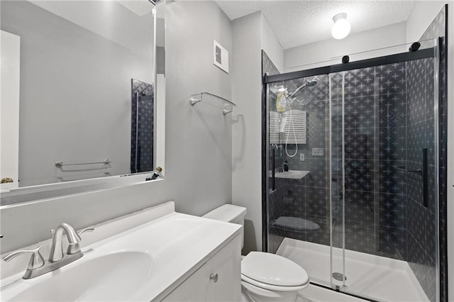 full bathroom with a textured ceiling, vanity, toilet, and a stall shower