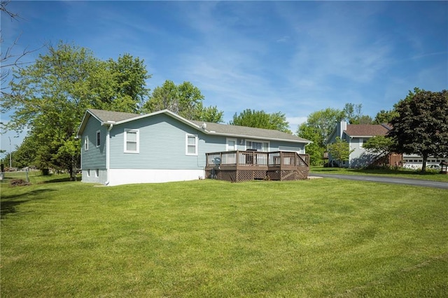 rear view of house featuring a deck and a lawn
