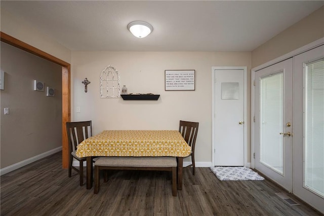 dining area with dark wood-type flooring, baseboards, and french doors