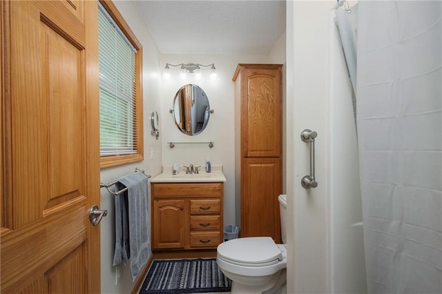 full bath featuring toilet, vanity, and a shower with shower curtain