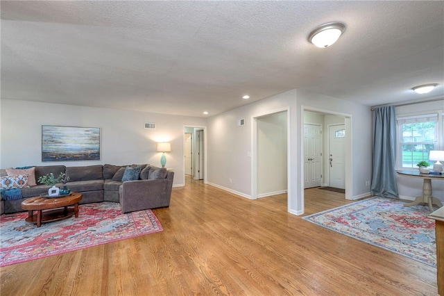 9711 Roe Ave, Overland Park, KS 66207 - living room with light wood finished floors, a textured ceiling, and recessed lighting