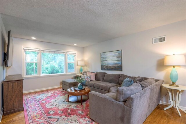 9711 Roe Ave, Overland Park, KS 66207 - living room featuring light wood-style floors, a textured ceiling, and recessed lighting