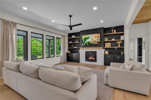 21851 179th St, Tonganoxie, KS 66086 - living area featuring ceiling fan, a glass covered fireplace, light wood-style floors, recessed lighting, and built in features