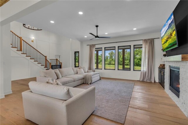 21851 179th St, Tonganoxie, KS 66086 - living room featuring stairs, recessed lighting, a stone fireplace, light wood finished floors, and a ceiling fan