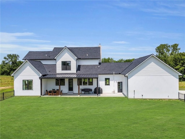 21851 179th St, Tonganoxie, KS 66086 - rear view of house featuring a standing seam roof, a patio, a metal roof, and a shingled roof