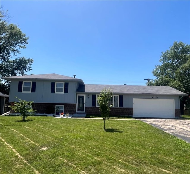 1424 S Olive St, Ottawa, KS 66067 - split level home featuring brick siding, concrete driveway, an attached garage, and a front yard