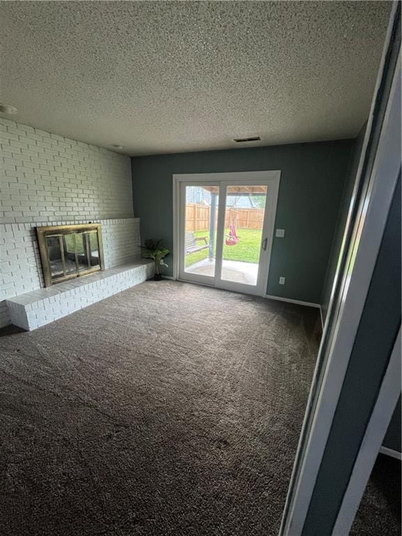 1424 S Olive St, Ottawa, KS 66067 - unfurnished living room with a textured ceiling, carpet flooring, and a fireplace