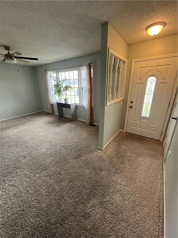 1424 S Olive St, Ottawa, KS 66067 - carpeted foyer featuring a textured ceiling and ceiling fan