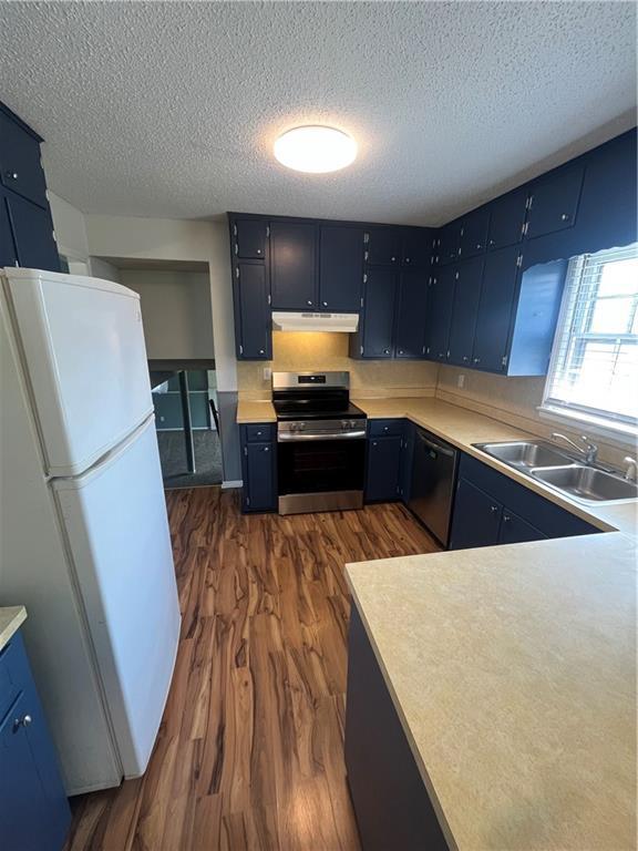1424 S Olive St, Ottawa, KS 66067 - kitchen with freestanding refrigerator, electric stove, under cabinet range hood, dishwasher, and dark wood-type flooring