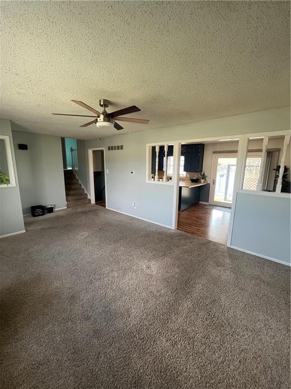 1424 S Olive St, Ottawa, KS 66067 - unfurnished living room featuring carpet flooring, a textured ceiling, and a ceiling fan