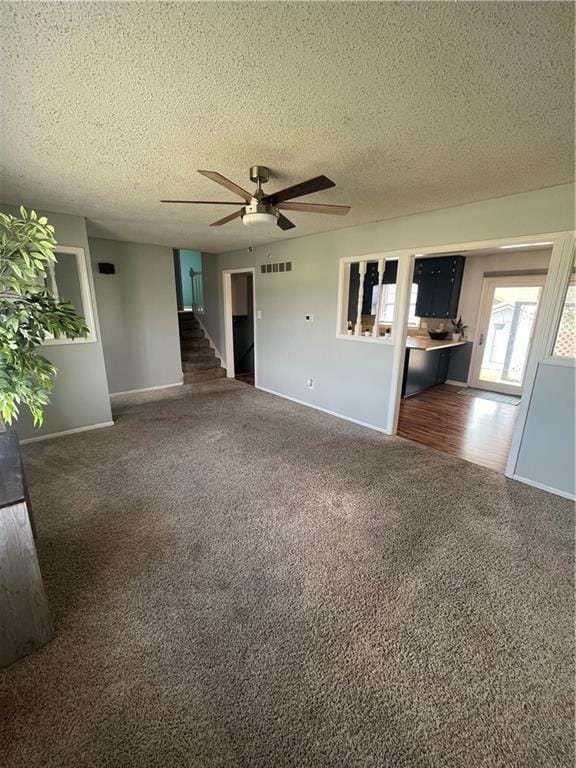 1424 S Olive St, Ottawa, KS 66067 - unfurnished living room with carpet floors, ceiling fan, and a textured ceiling