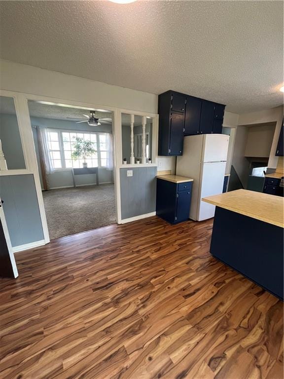 1424 S Olive St, Ottawa, KS 66067 - kitchen featuring freestanding refrigerator, a textured ceiling, dark wood finished floors, light countertops, and a ceiling fan