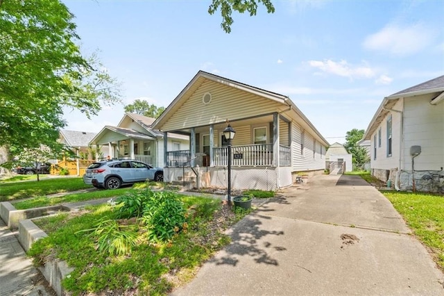 1212 E 22nd Ave, North Kansas City, MO 64116 - view of front of home featuring a porch and concrete driveway