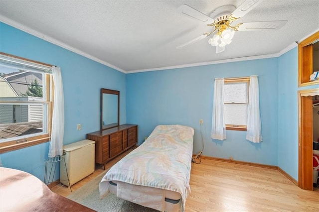 1212 E 22nd Ave, North Kansas City, MO 64116 - bedroom with light wood-style floors, multiple windows, crown molding, a textured ceiling, and ceiling fan