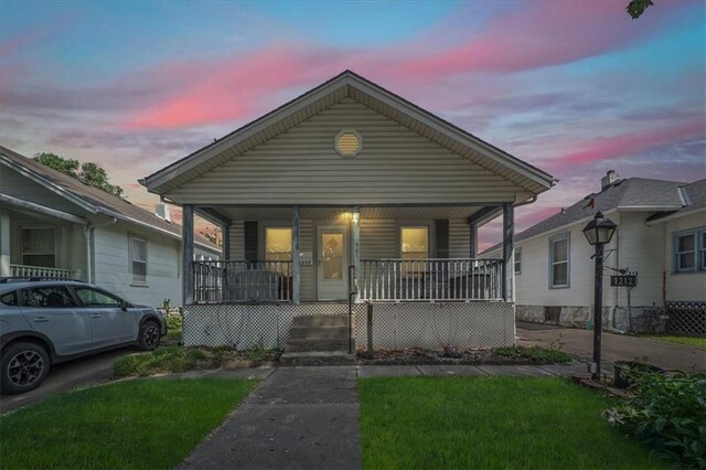1212 E 22nd Ave, North Kansas City, MO 64116 - view of front facade featuring covered porch and a front lawn