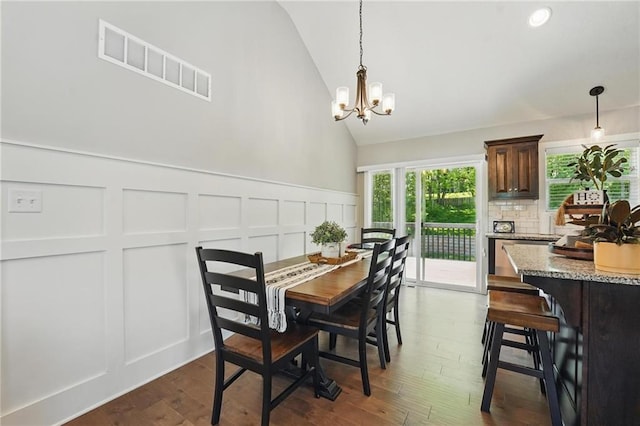19553 E 14th St N, Independence, MO 64056 - dining room featuring a decorative wall, a chandelier, dark wood-style flooring, wainscoting, and high vaulted ceiling