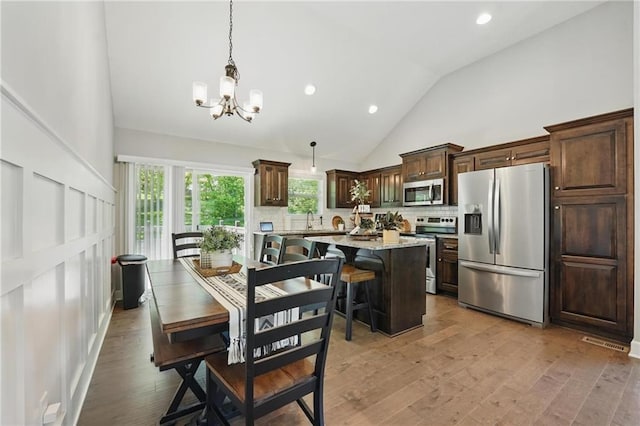 19553 E 14th St N, Independence, MO 64056 - dining space featuring a chandelier, light wood-type flooring, high vaulted ceiling, and recessed lighting