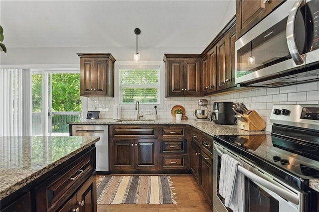 19553 E 14th St N, Independence, MO 64056 - kitchen featuring appliances with stainless steel finishes, a sink, light wood finished floors, dark brown cabinets, and decorative backsplash