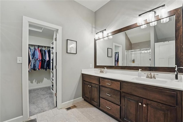 19553 E 14th St N, Independence, MO 64056 - bathroom featuring double vanity, a spacious closet, a shower stall, and baseboards
