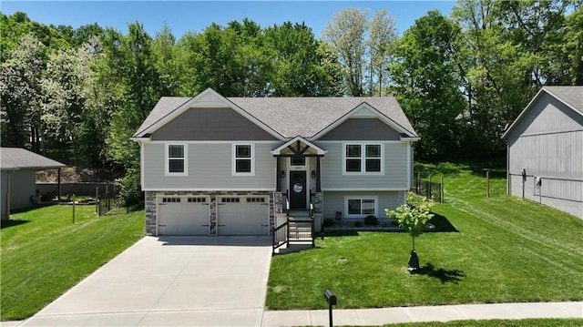 19553 E 14th St N, Independence, MO 64056 - split foyer home featuring a garage, concrete driveway, and view of wooded area