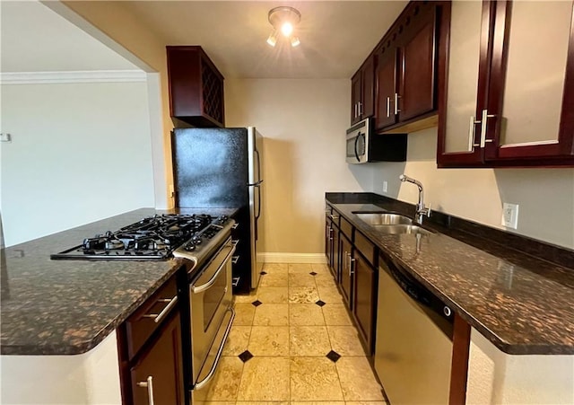 700 E 8th St Unit 10J, Kansas City, MO 64106 - kitchen featuring stainless steel appliances, a sink, dark stone countertops, baseboards, and glass insert cabinets