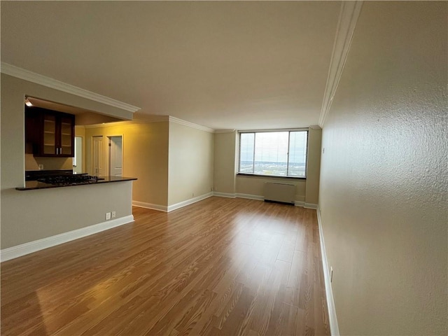700 E 8th St Unit 10J, Kansas City, MO 64106 - unfurnished living room with ornamental molding, wood finished floors, and baseboards