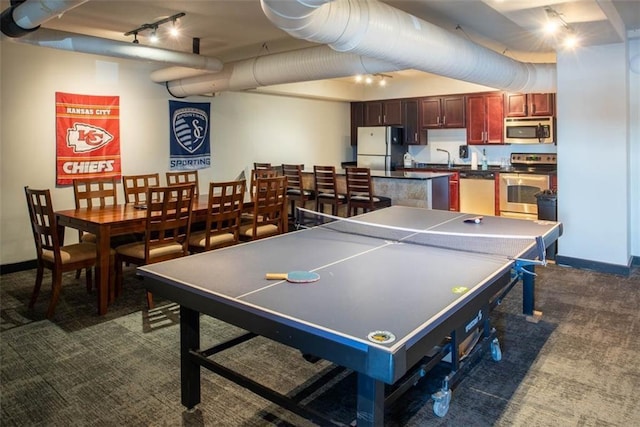 700 E 8th St Unit 10J, Kansas City, MO 64106 - recreation room featuring rail lighting, dark colored carpet, baseboards, and a sink