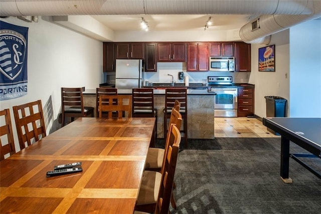 700 E 8th St Unit 10J, Kansas City, MO 64106 - kitchen with stainless steel appliances, dark countertops, and reddish brown cabinets