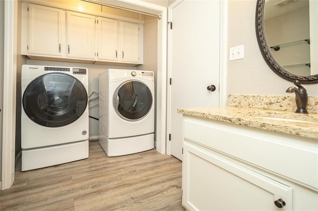 3668 Colorado Rd, Pomona, KS 66076 - laundry room featuring cabinet space, washing machine and clothes dryer, and light wood finished floors