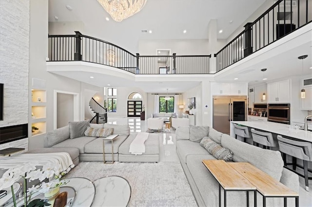5645 Legler St, Shawnee, KS 66217 - living room featuring a towering ceiling, stairway, built in shelves, recessed lighting, and a fireplace