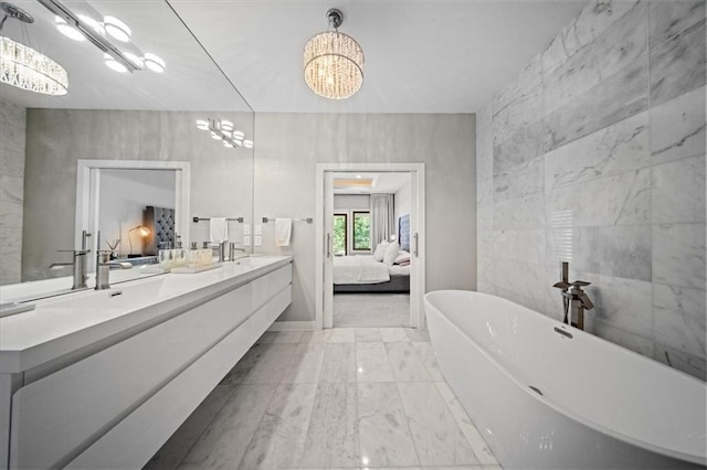 5645 Legler St, Shawnee, KS 66217 - ensuite bathroom featuring a chandelier, double vanity, a freestanding tub, and marble look tiles