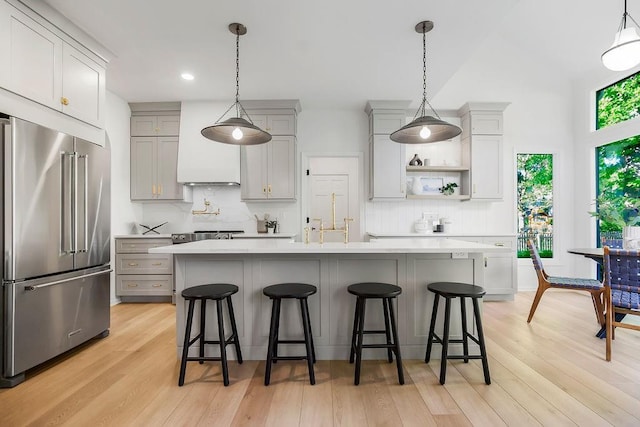 kitchen featuring high end refrigerator, gray cabinetry, light countertops, and recessed lighting