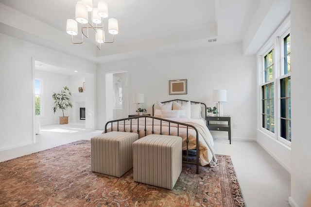 bedroom featuring a chandelier, multiple windows, and a raised ceiling